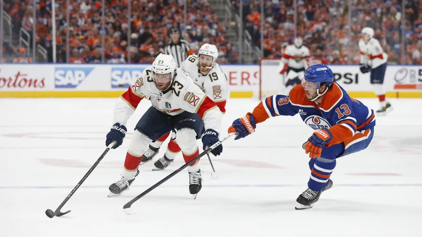 Jogadores disputam o puck no jogo 1 da grande final da Stanley Cup de 2025, disputada entre Panthers e Oilers no dia 04/06/25, em Edmonton. Fonte: NHL (2025)