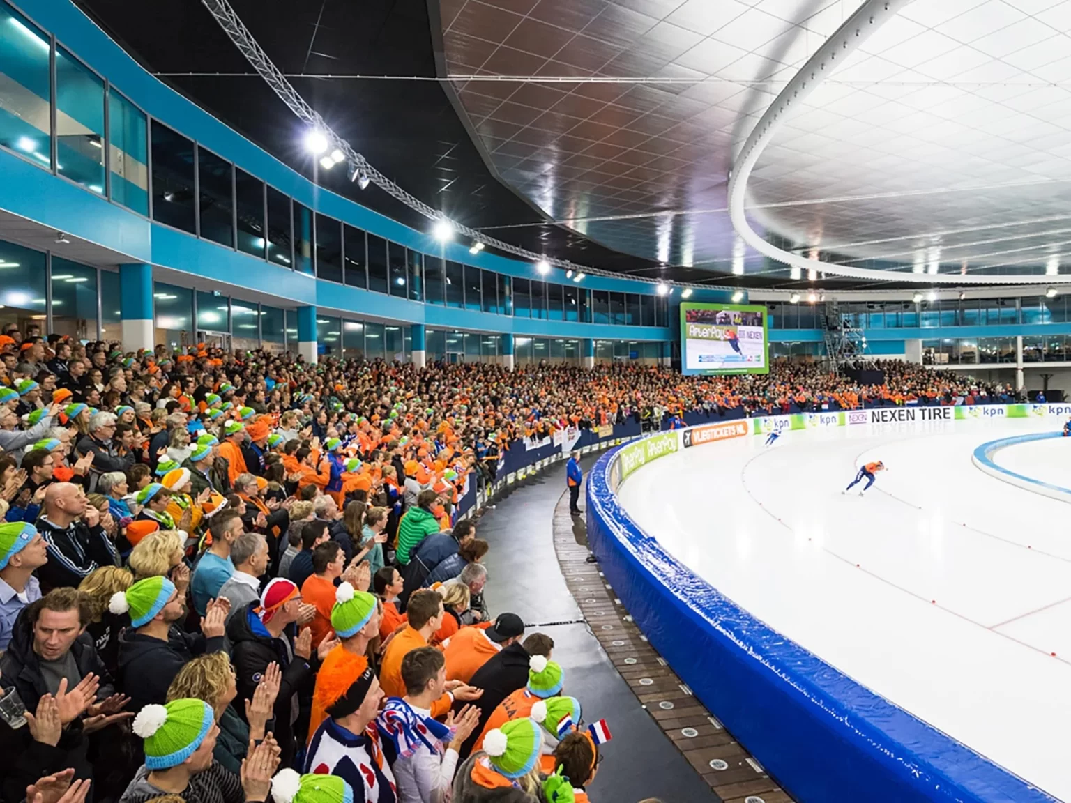 Competição de patinação de velocidade em pista longa, com a grande torcida da Holanda assistindo - Fonte: Olympics (2026)