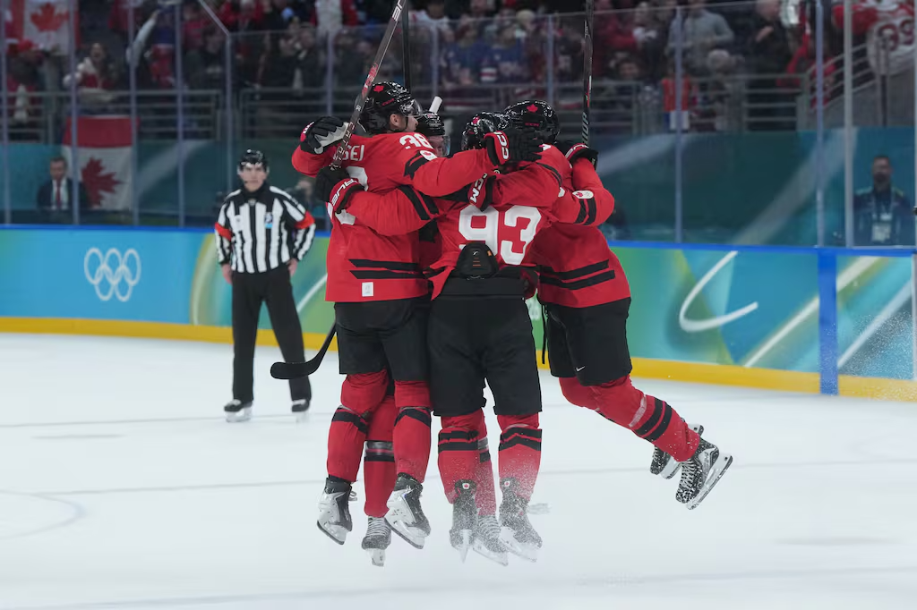Jogadores da Seleção Canadense comemoram o gol da vitória de Mitch Marner nas quartas de final do hockey masculino nos Jogos Olímpicos de Inverno de 2026, na quarta-feira, 18 de fevereiro de 2026. Foto: THE CANADIAN PRESS/Darryl Dyck – Fonte: CP24 (2026)