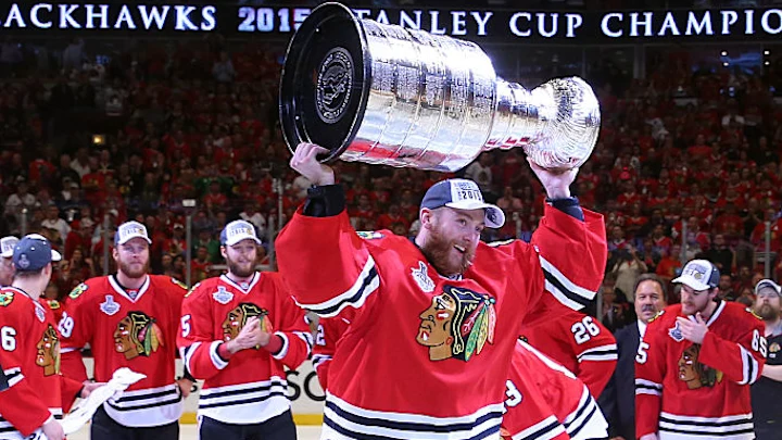 Jogador do Chicago Blackhawk levanta a Stanley Cup ganha em 2015 contra a equipe do Tampa Bay Lightning, no jogo 6, no dia 15/06/2025 – Por: Ty Glenn - Foto: Bruce Bennett /GettyImages – Fonte: Blackhawkup.com (2025)