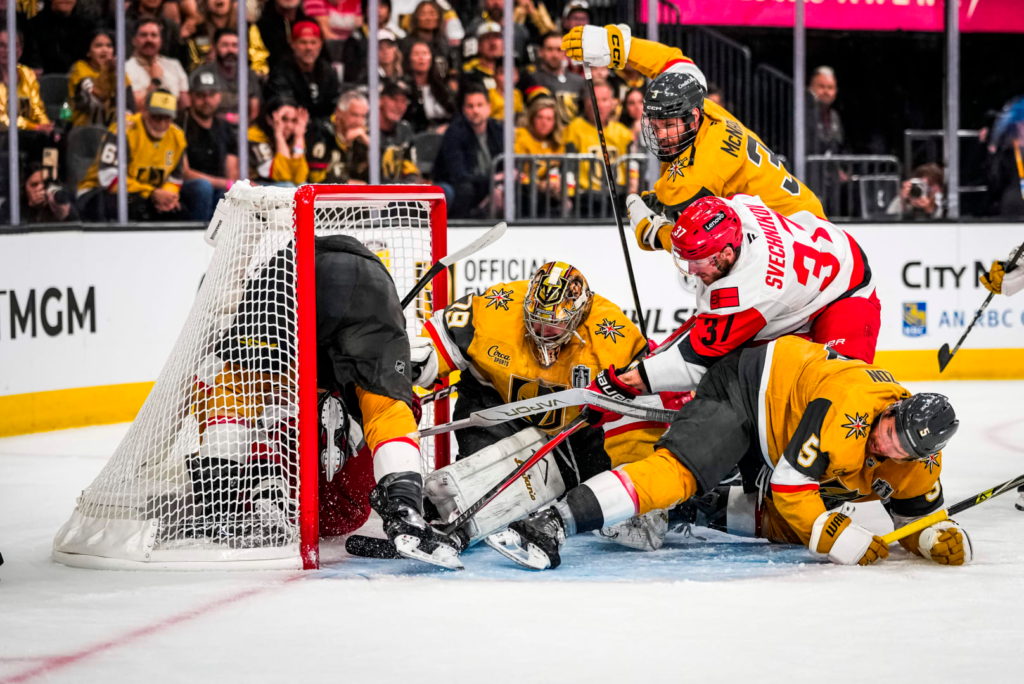 Jogador do Carolina, Andrei Svechnikov, disputa o disco com o goleiro de Vegas no jogo 3 da final da Stanley Cup 2026, entre as equipes de Vegas Golden Knights e Carolina Hurricanes - Foto: © Josh Lavallee/Carolina Hurricanes – Fonte: NHL (2026)
