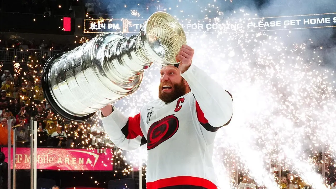 Jordan Staal, capitão do Carolina Hurricanes, levanta a Stanley Cup após a vitória sobre o Vegas Golden Knights no Jogo 6 da final da Stanley Cup 2026 – CAR@VGK, SCF, Gm 6: Hurricanes celebrate as Stanley Cup champions – Fonte: NHL (2026).