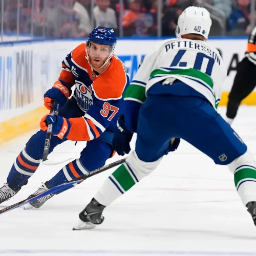 1- Connor McDavid Disputa o puck em jogo contra o Vancouver Canucks em 11/10/2025 – Fonte: NHL (2025)
