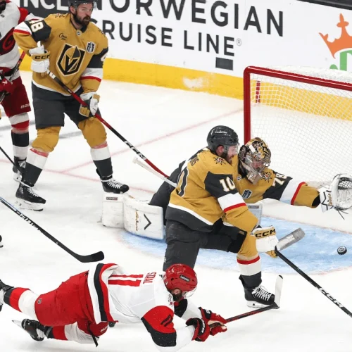 Mesmo caindo Jordan Staal (número 11), consegue tocar o puck e fazer o gol, no jogo 4 da final da Stanley Cup 2026 entre as equipes de Vegas e Carolina - CAR@VGK, SCF – Fonte: NHL (2026).