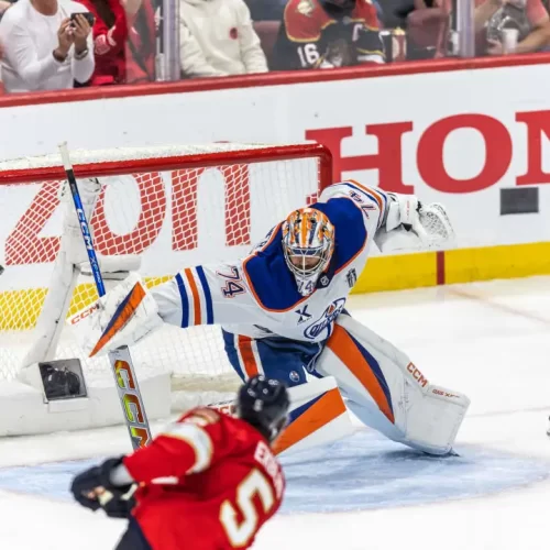 O jogador do Panthers, Aaron Ekblad (5) chuta para o gol de Stuart Skinner, dos Oilers, no jogo 3 da final da Stanley Cup, disputada no dia 09/06/2025 na Amerant Bank Arena, em Sunrise, Flórida. Fonte: NHL (2025).
