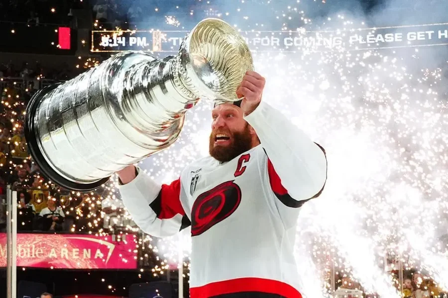 Jordan Staal, capitão do Carolina Hurricanes, levanta a Stanley Cup após a vitória sobre o Vegas Golden Knights no Jogo 6 da final da Stanley Cup 2026 – CAR@VGK, SCF, Gm 6: Hurricanes celebrate as Stanley Cup champions – Fonte: NHL (2026).